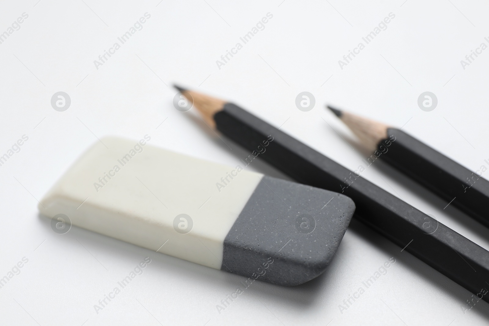 Photo of Eraser and pencils on white background, closeup