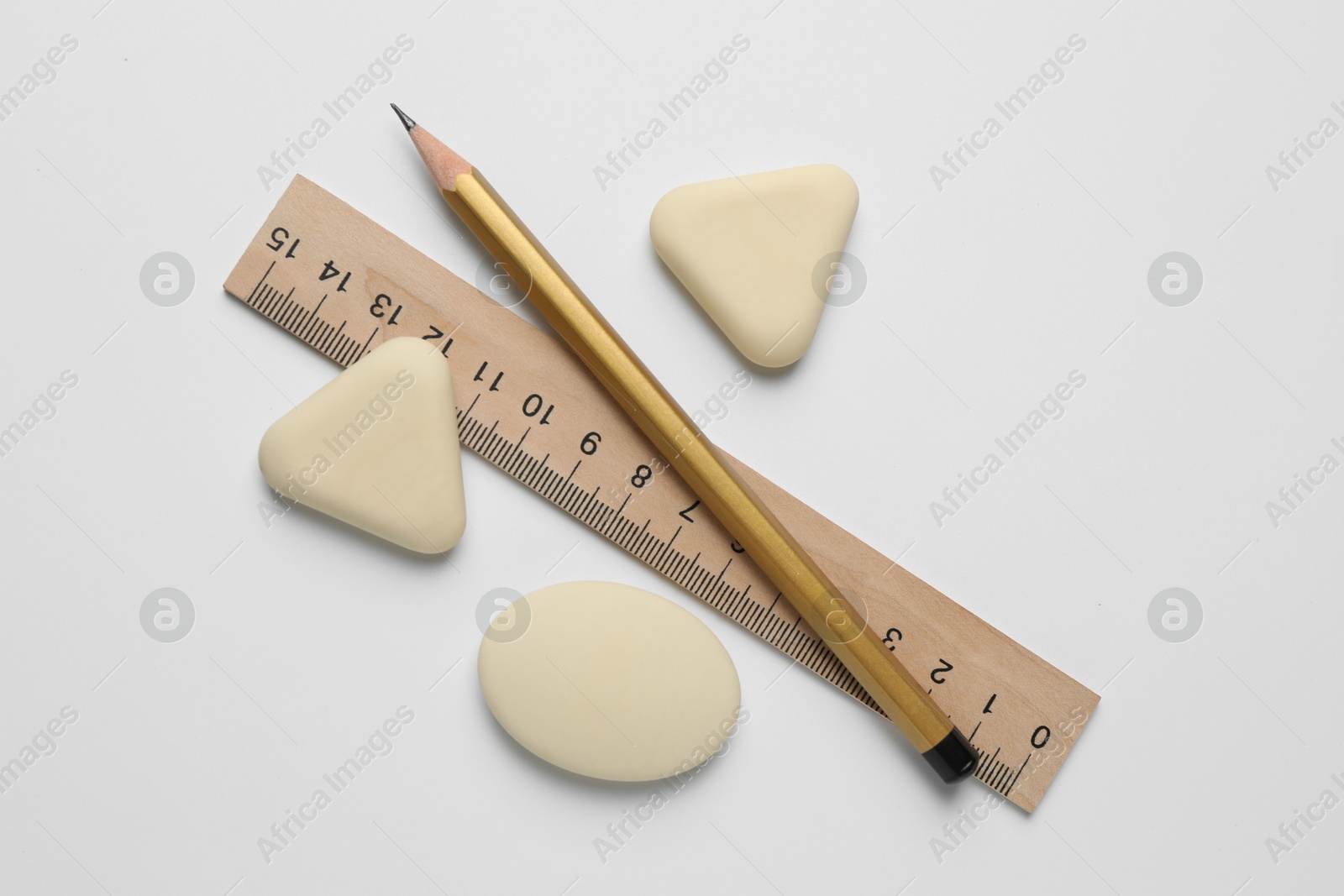 Photo of Erasers, ruler and pencil on white background, flat lay