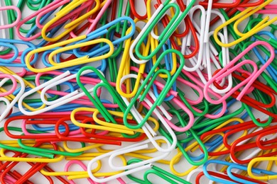 Photo of Many colorful paper clips on white background, top view