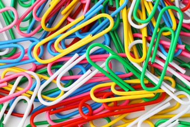 Many colorful paper clips on white background, top view