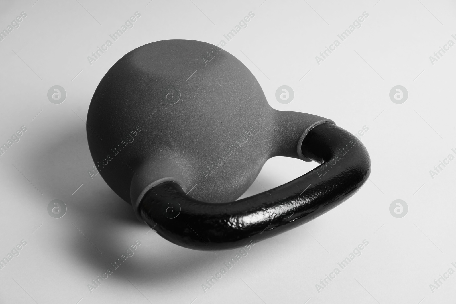 Photo of One metal kettlebell on grey background, closeup. Sports equipment