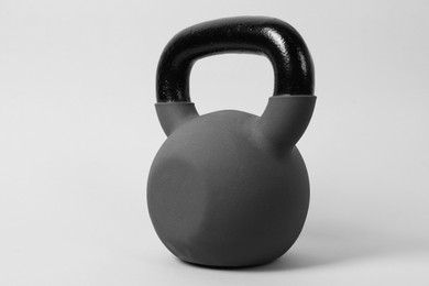 Photo of One metal kettlebell on grey background. Sports equipment