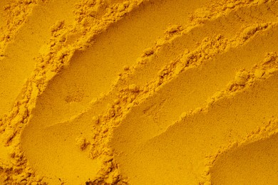 Photo of Aromatic turmeric powder as background, top view