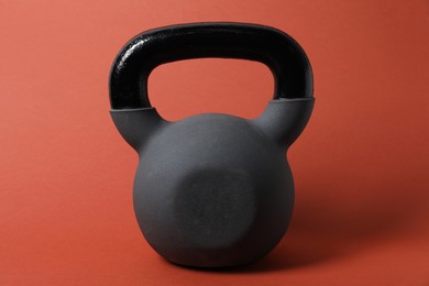 Photo of One kettlebell on orange background. Sport equipment