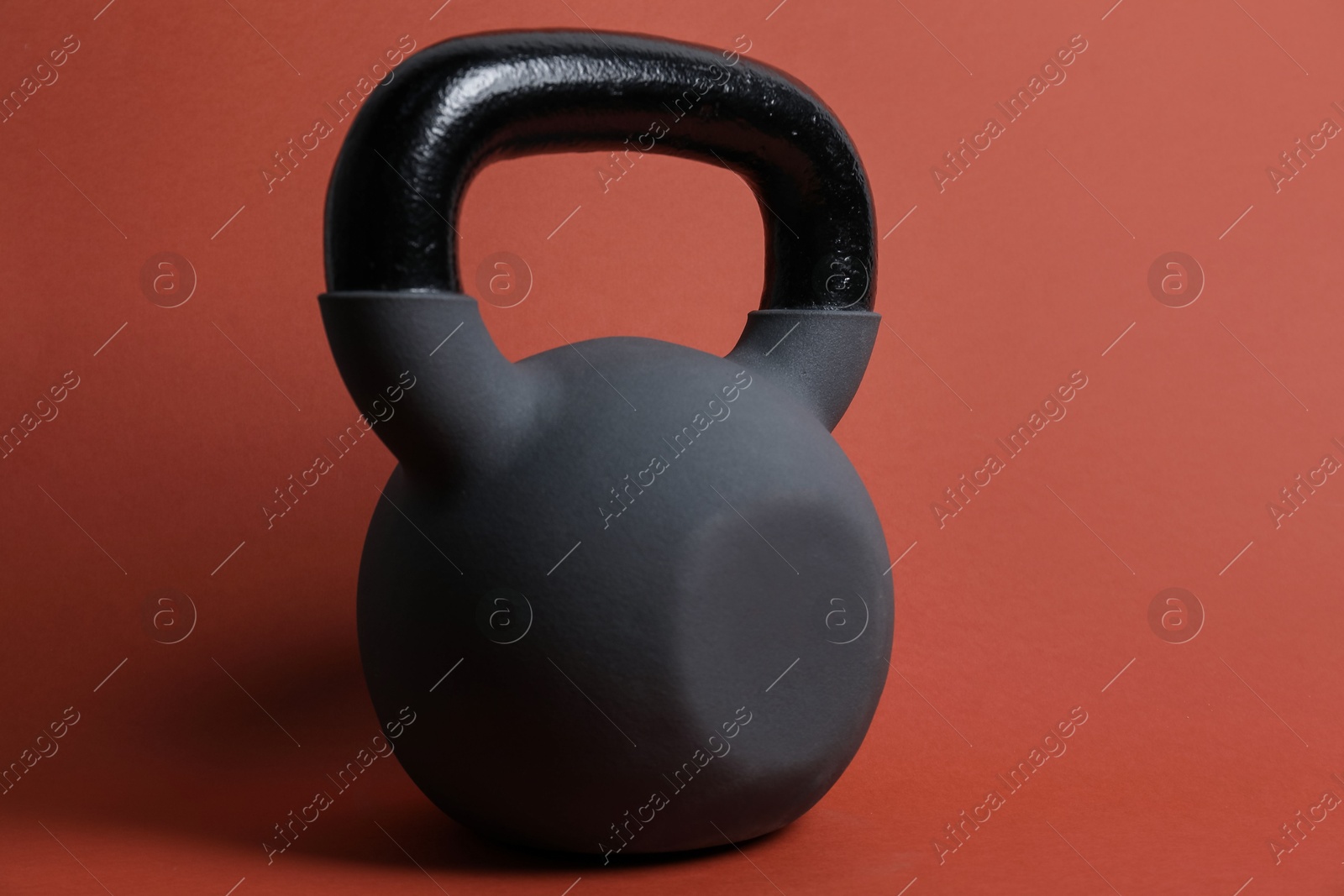 Photo of One kettlebell on orange background. Sport equipment