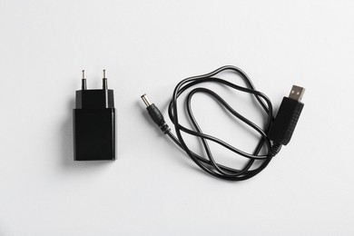 Photo of USB power adapter and charge cable on white background, flat lay