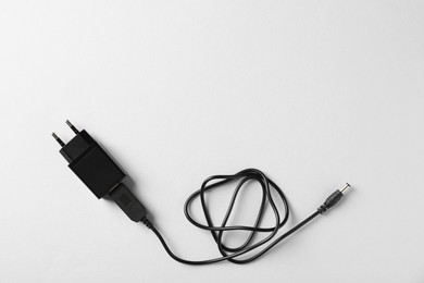 Photo of USB power adapter with charge cable on white background, top view