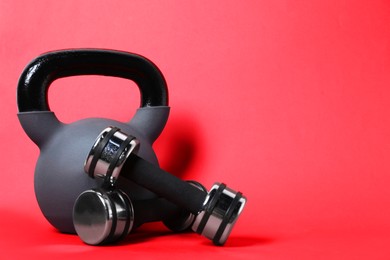 Photo of Kettlebell and dumbbells on red background. Space for text