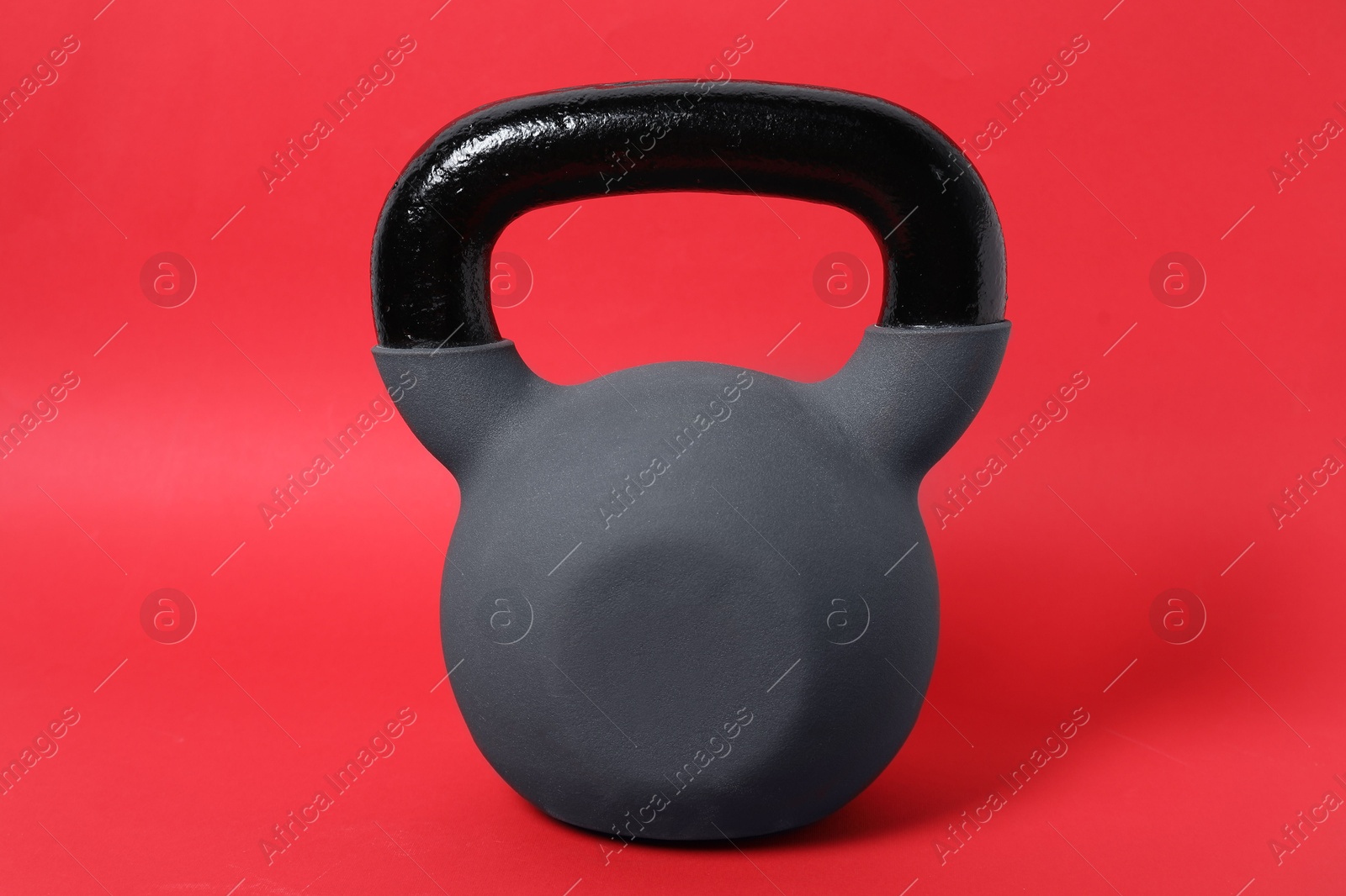 Photo of One kettlebell on red background. Sport equipment