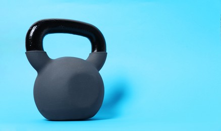 Photo of One kettlebell on light blue background. Space for text