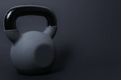 Photo of One kettlebell on black background. Space for text