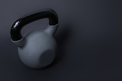 Photo of One kettlebell on black background. Space for text