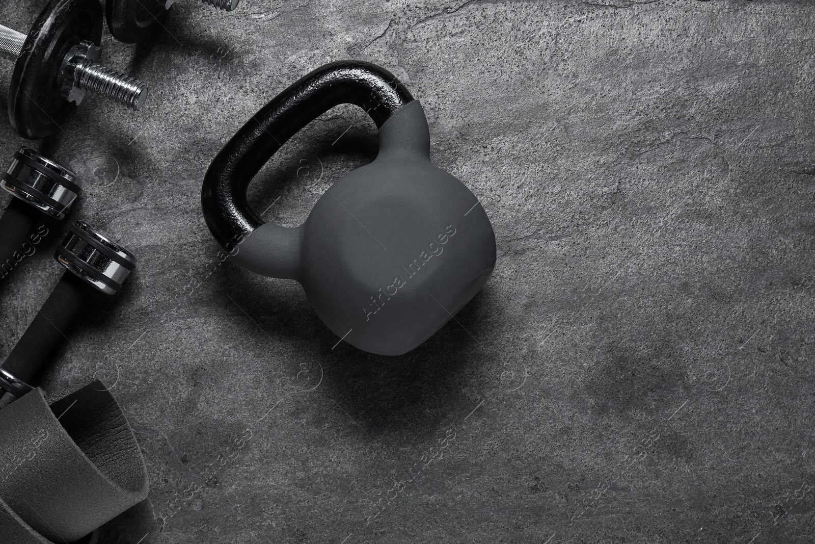 Photo of Kettlebell and dumbbells on grey background, flat lay. Space for text