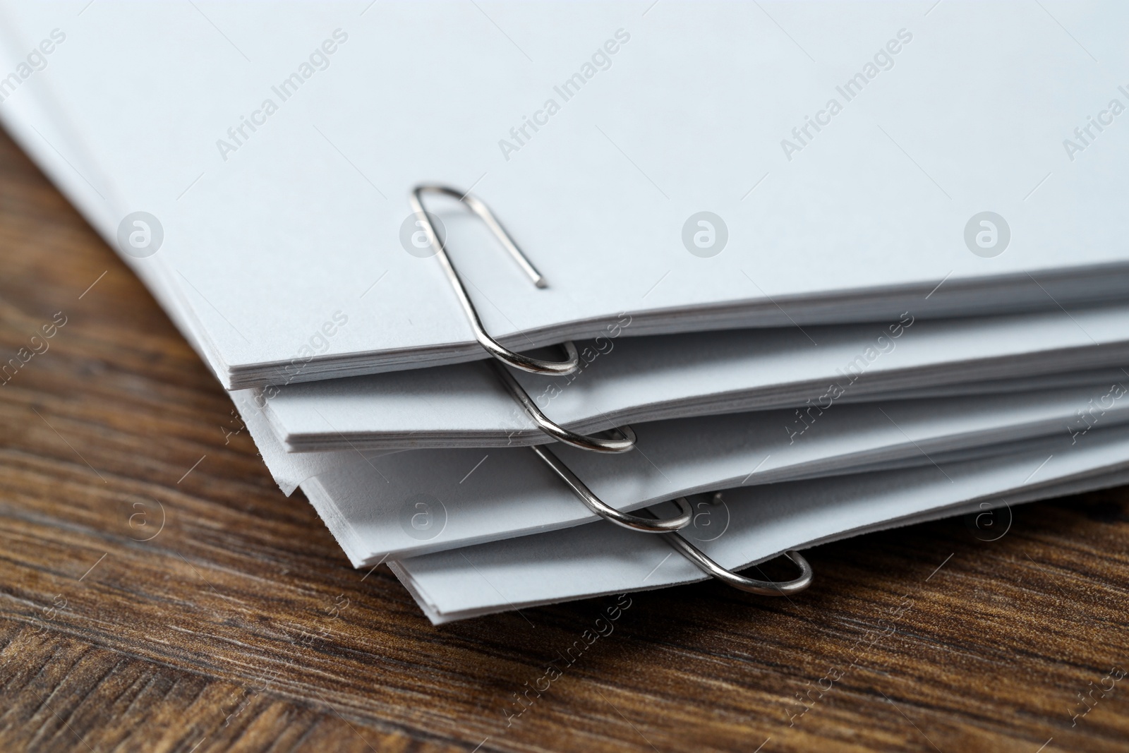 Photo of Paper notes with clips on wooden table, closeup