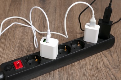 Photo of USB adapters with charge cables in power strip on floor, closeup