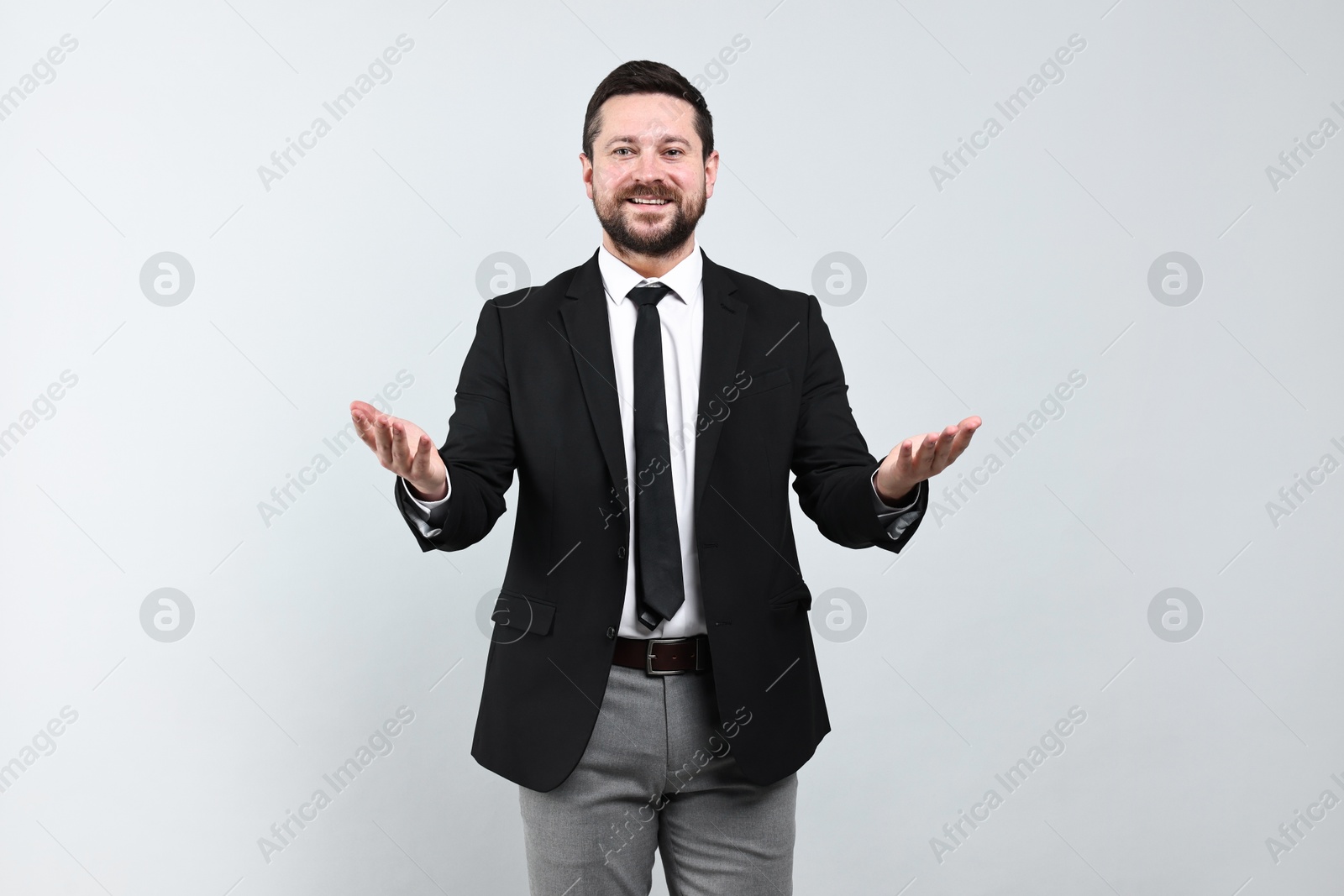 Photo of Happy businessman welcoming clients or partners on grey background