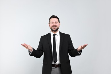 Photo of Happy businessman welcoming clients or partners on grey background