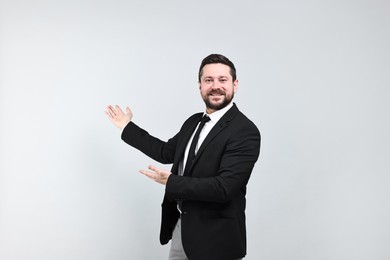 Photo of Happy businessman welcoming clients or partners on grey background