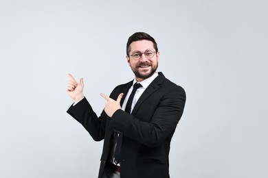 Photo of Happy businessman welcoming clients or partners on grey background