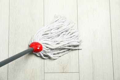 String mop on wooden floor, above view. Cleaning equipment