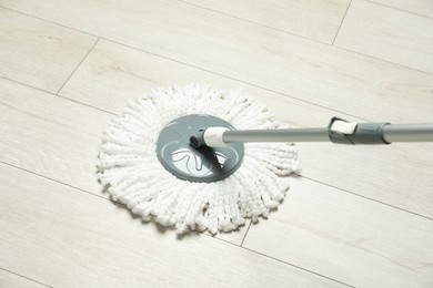 String mop on wooden floor. Cleaning equipment