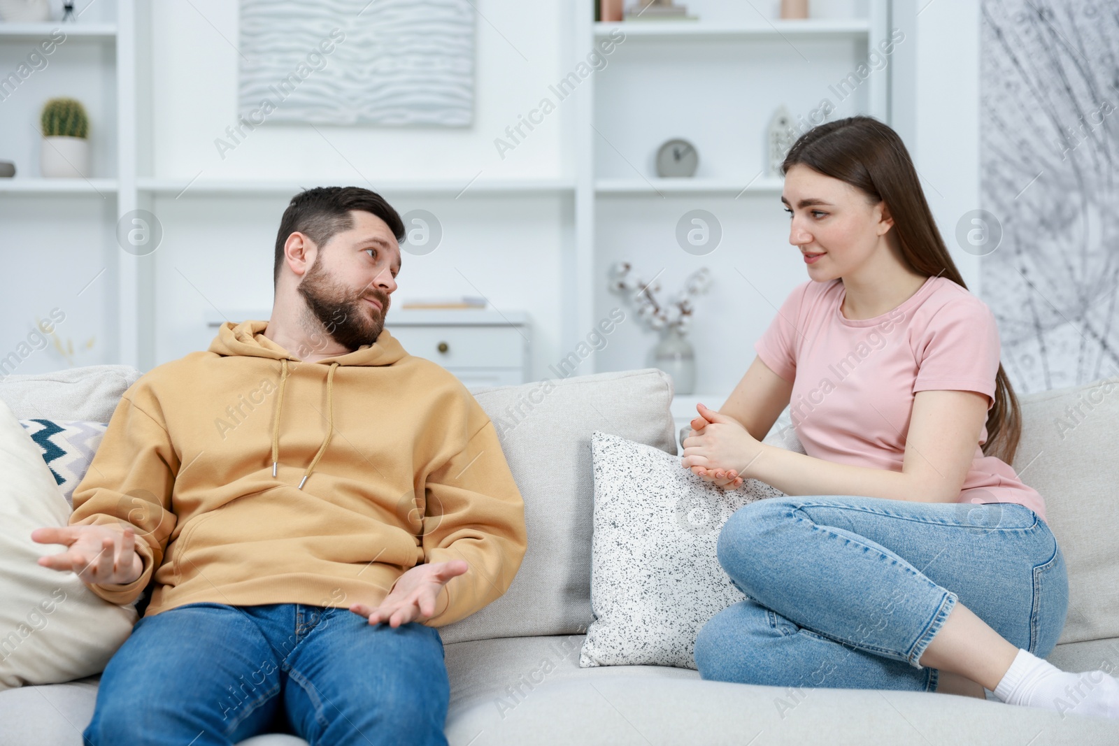 Photo of Woman sitting on couch near her resentful boyfriend at home