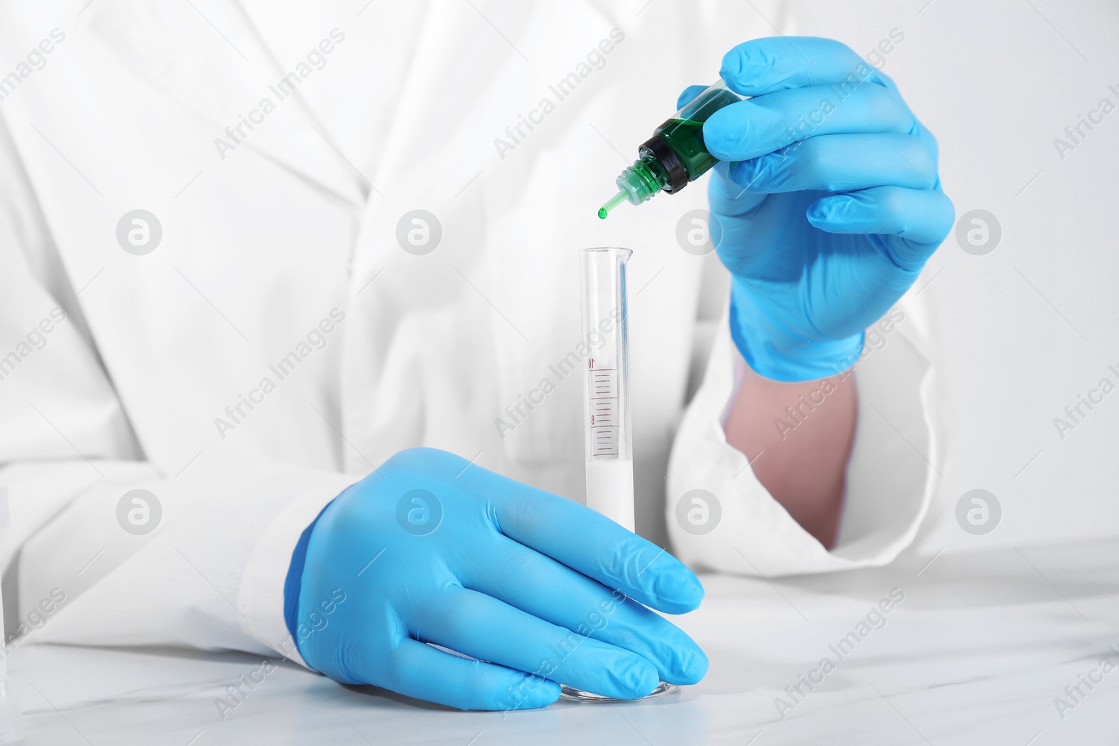 Photo of Laboratory testing. Scientist working with test tube at white marble table, closeup