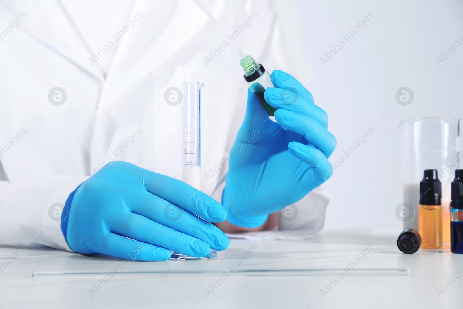 Photo of Laboratory testing. Scientist working with test tubes at white marble table, closeup