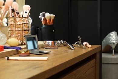 Photo of Makeup room. Different beauty products on wooden dressing table indoors