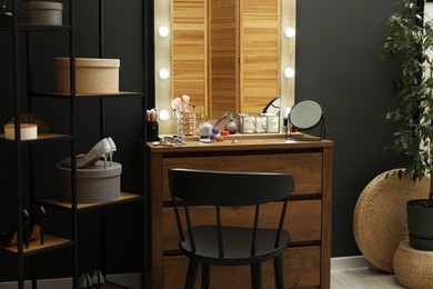 Photo of Makeup room. Mirrors, different beauty products, shoes, dresser and chair indoors