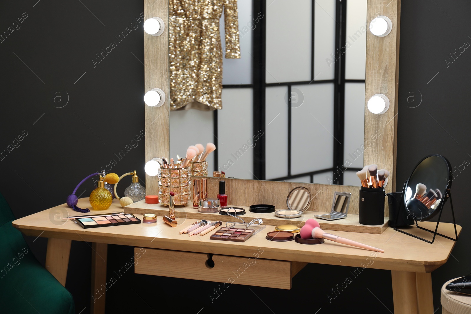 Photo of Makeup room. Wooden dressing table with mirror and different beauty products indoors