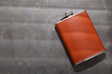 Photo of One hip flask on grey table, top view. Space for text