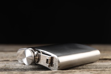 One hip flask on wooden table, closeup