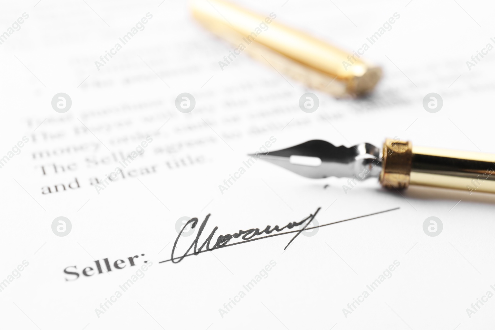 Photo of Signature and fountain pen on paperwork, closeup view