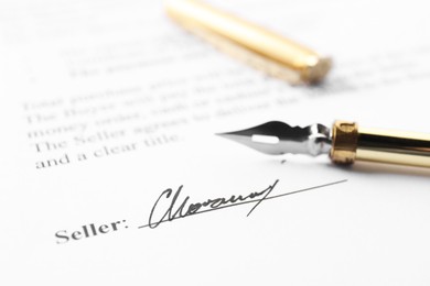 Photo of Signature and fountain pen on paperwork, closeup view