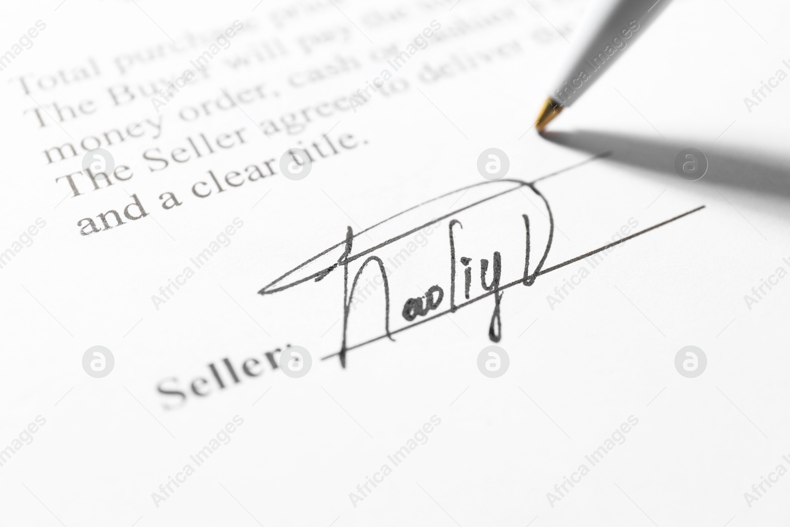 Photo of Signature and pen on paperwork, closeup view