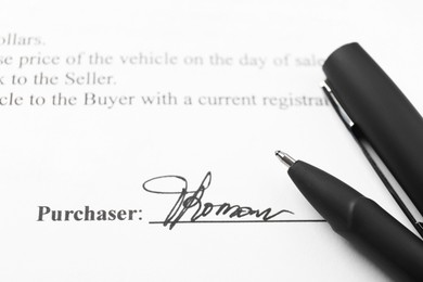 Photo of Signature and pen on paperwork, closeup view