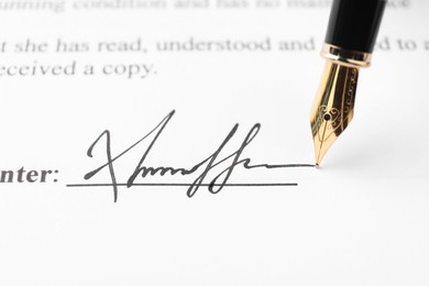 Photo of Fountain pen leaving signature on contract, closeup