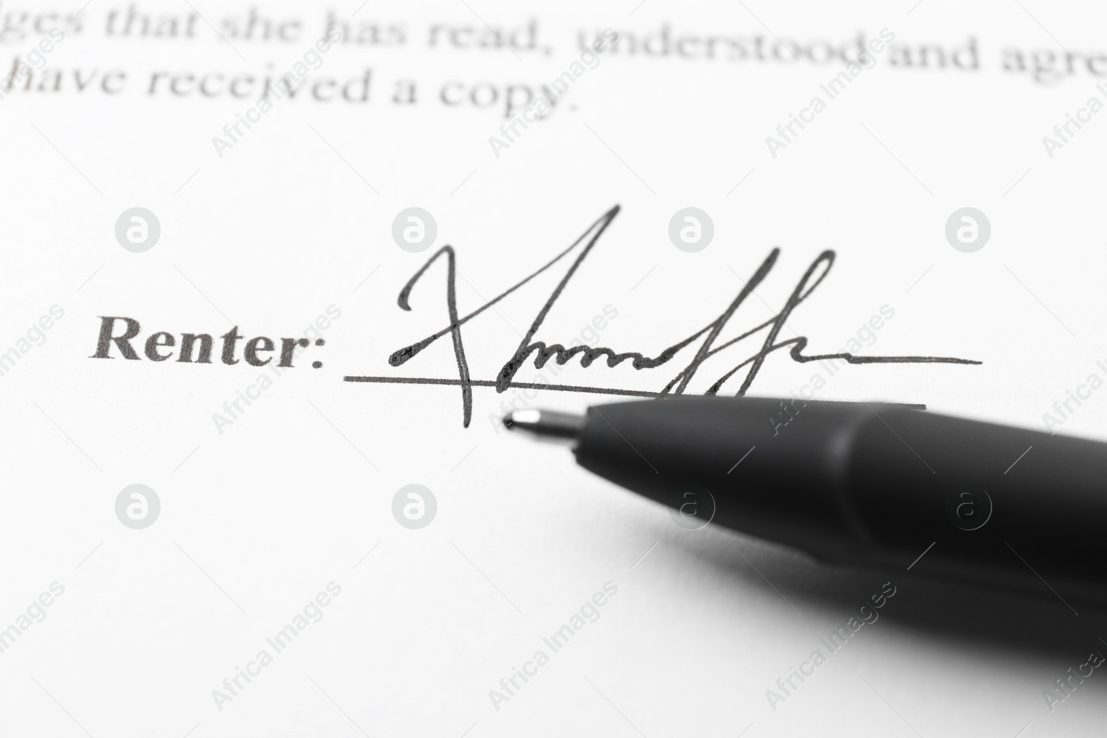 Photo of Signature and pen on paperwork, closeup view