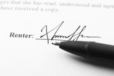 Photo of Signature and pen on paperwork, closeup view