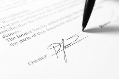 Photo of Pen leaving signature on contract, closeup view