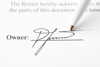 Photo of Signature and pen on paperwork, closeup view