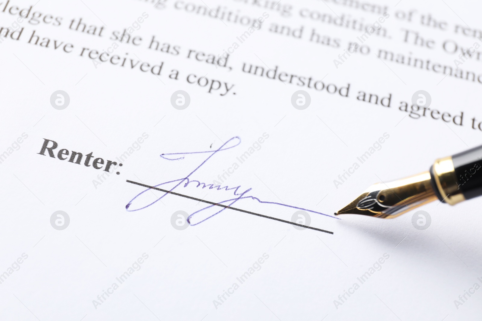 Photo of Fountain pen leaving signature on contract, closeup