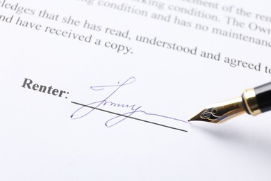 Photo of Fountain pen leaving signature on contract, closeup