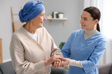 Nurse supporting woman with cancer at home