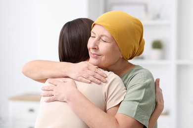 Photo of Woman with cancer and her daughter hugging at home