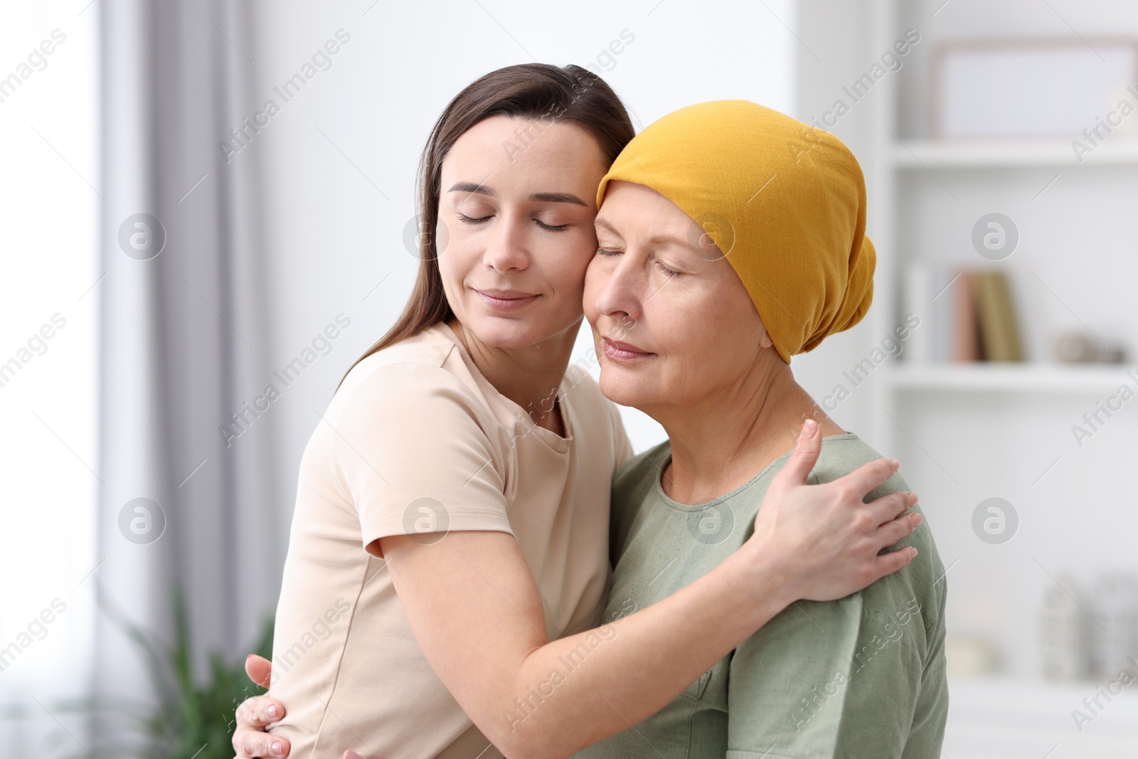 Photo of Woman with cancer and her daughter hugging at home