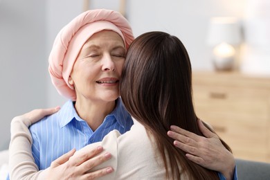 Photo of Woman with cancer and her daughter hugging at home