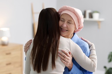 Photo of Woman with cancer and her daughter hugging at home