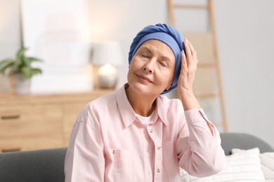 Senior woman with cancer on sofa at home